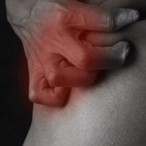 a mans hand clutching a knee with arthritic pain.