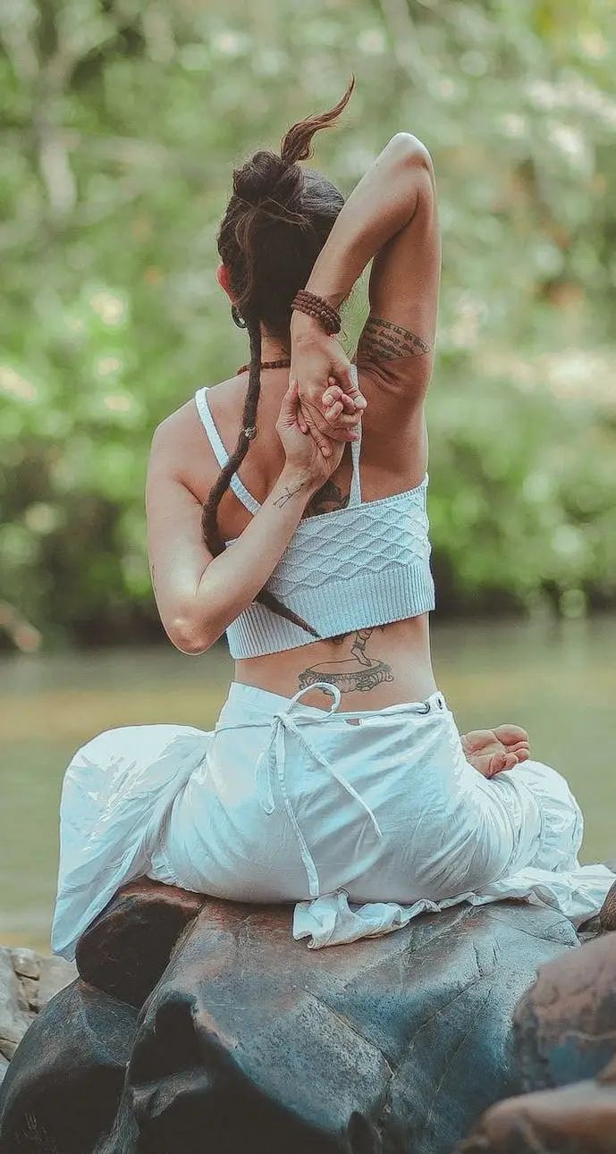 lady doing yoga beside a stream